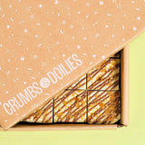 Bueno Brownie by Crumbs & Doilies with white chocolate, hazelnut filling, and crunchy feuilletine pieces in branded box.